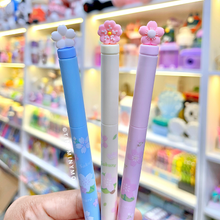 Load image into Gallery viewer, Three Sakura Gel Pen held in front of a store shelf - Tinyminymo
