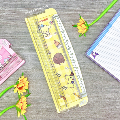 Yellow Paper Trimmer on a Grey Surface with Stationery Items around - Tinyminymo